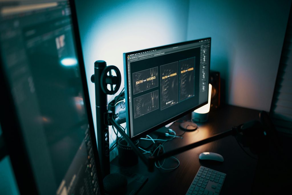 A stylish modern workspace with dual monitors displaying design software in a dimly lit room.